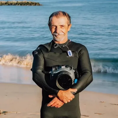 Greg Rabejac photographe aquatique pose avec son caisson étanche devant la baie de Socoa