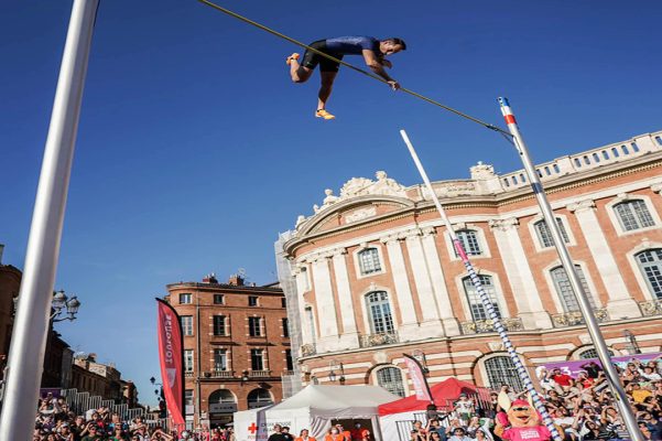 Perchiste en haut de saut sur la lace du Capitole à Toulouse un jour d'exhibition par grand beau temps