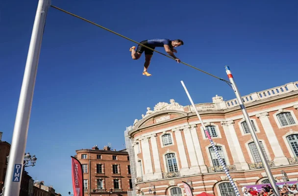 Perchiste en haut de saut sur la lace du Capitole à Toulouse un jour d'exhibition par grand beau temps